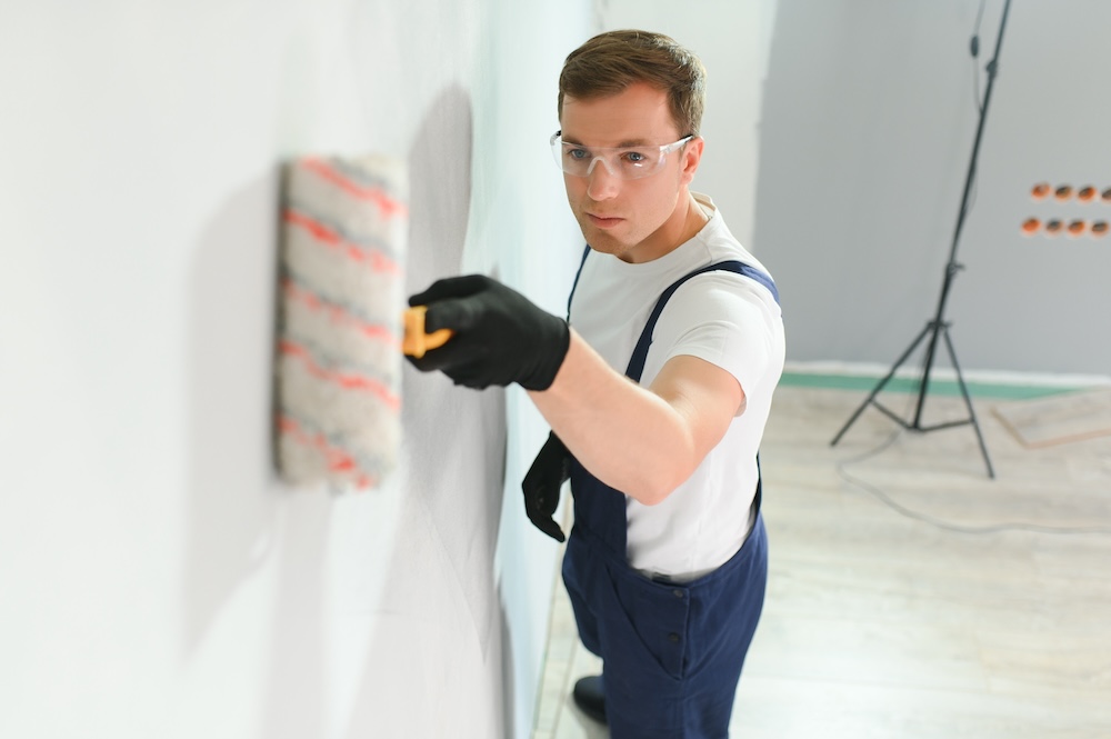 pracownik budowlany malujący ścianę 